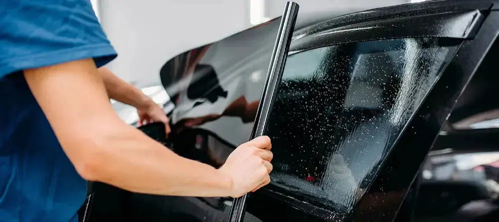 Photo close up of an installer fitting car window tint