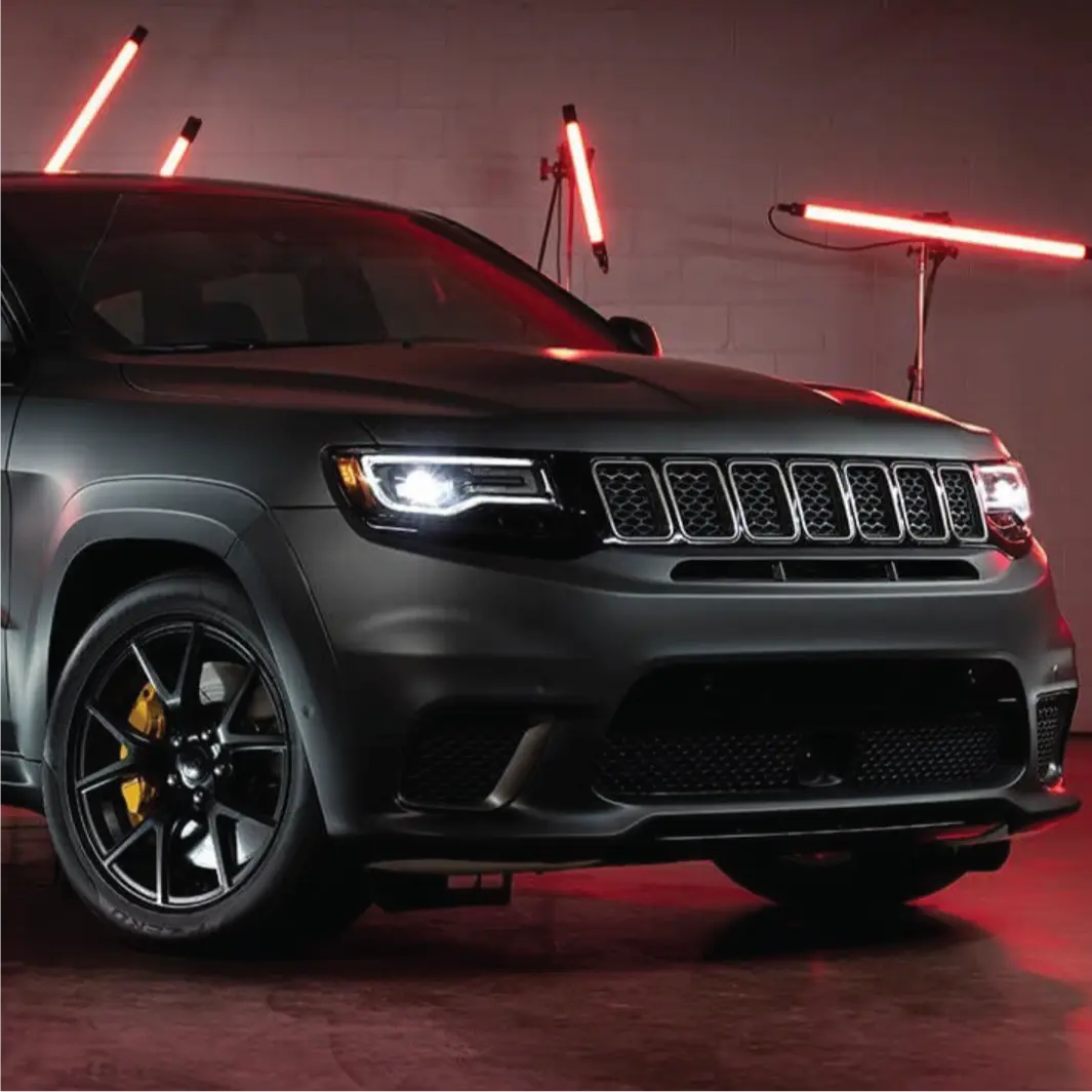3M 2080 matt black vinyl wrap installed on a Jeep SUV in a dimly lit garage with red lights.
