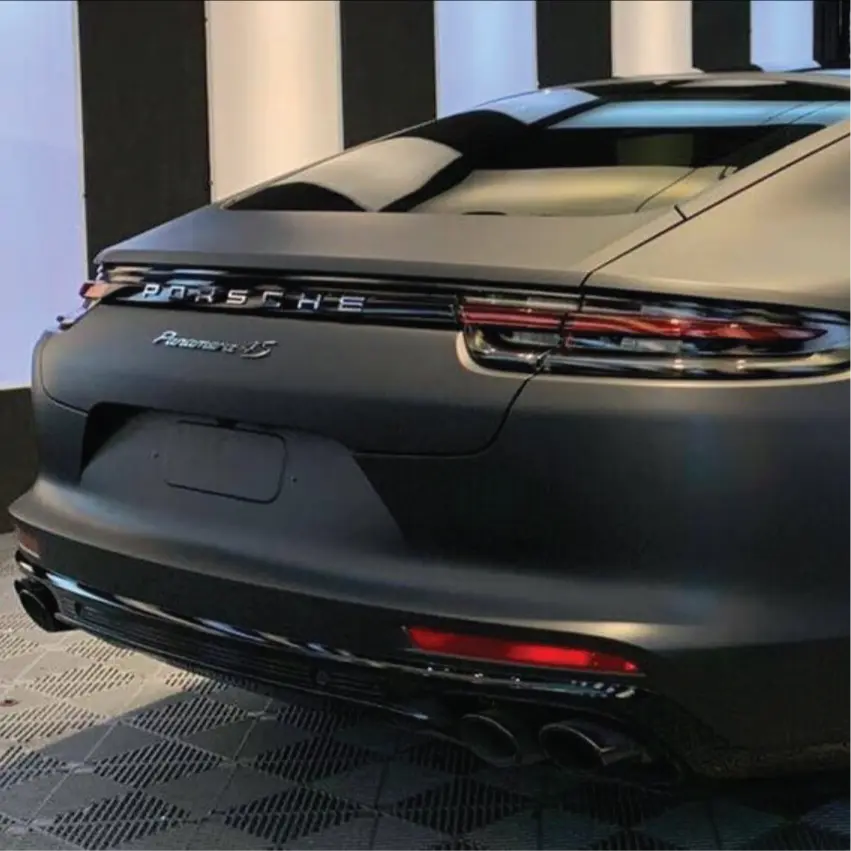 Back view of a Porsche Panamera 4S car in a showroom setting with 3M 2080 matt black wrap installed 