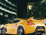 Oracal matte safron yellow wrapped sports car with a large spoiler on a city street at night