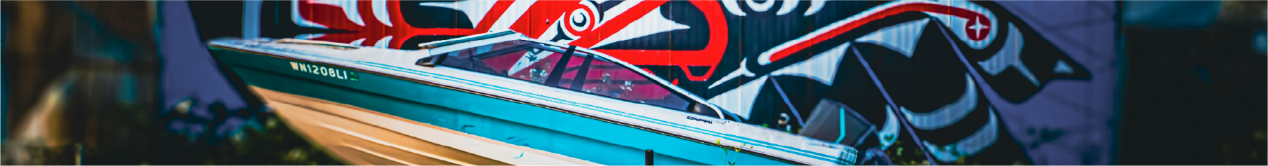 Boat wrapping installed to the hull with graffiti in the background