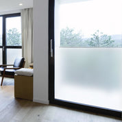 Modern interior with a sliding glass door with frosted window vinyl installed and a chair