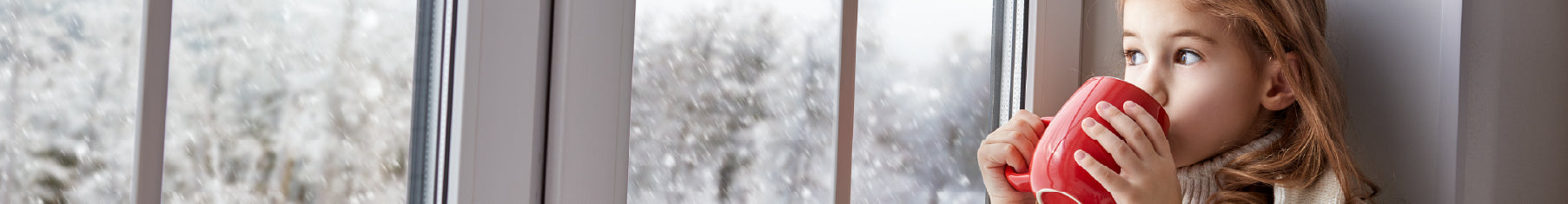 Child looking through the windows at wintery view with insulating window film installed