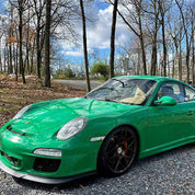 Oracal Gloss Police Green installed on a car parked on a gravel road with trees