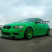 Oracal Gloss Police Green installed on a car on a track with a cloudy sky