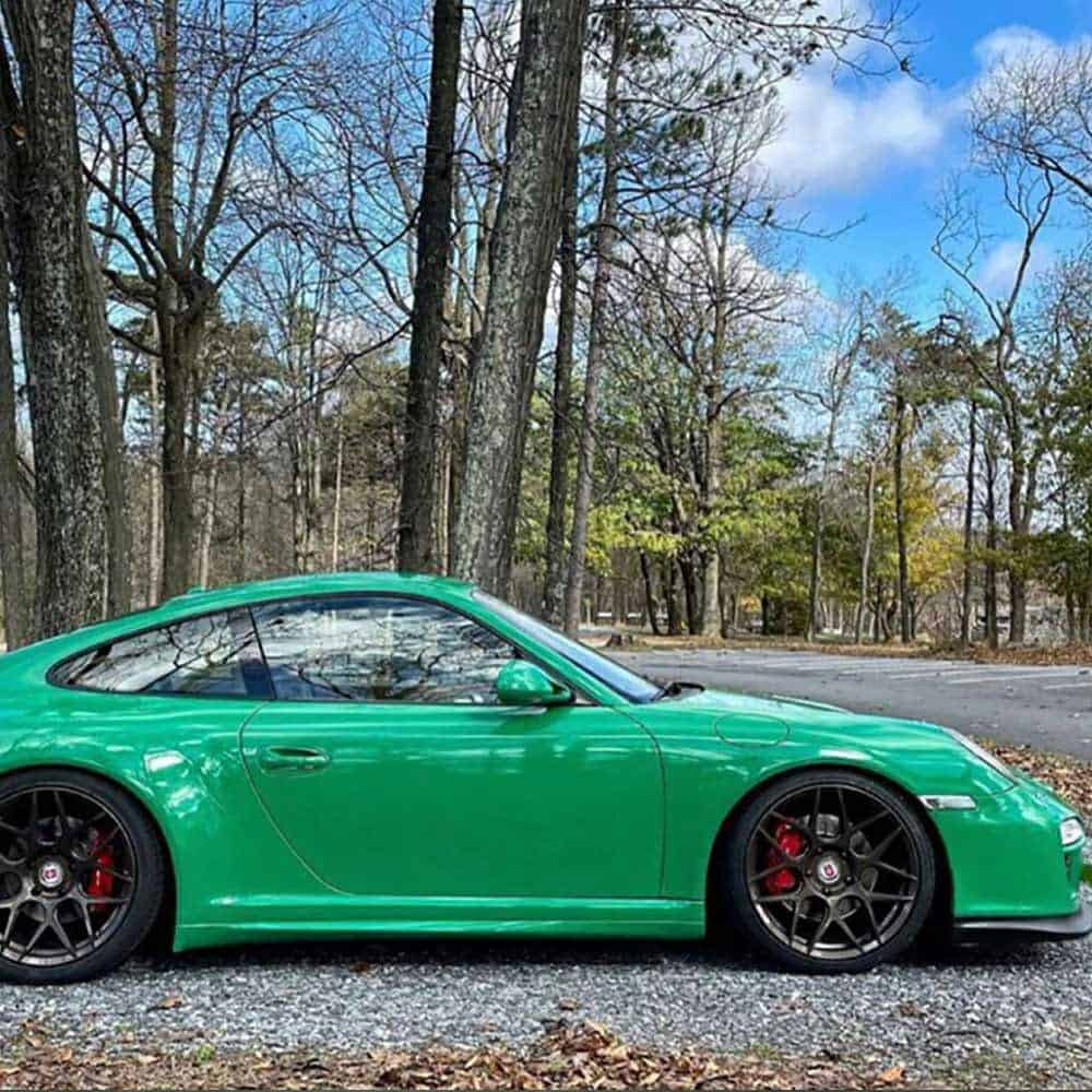 Oracal Gloss Police Green installed on a car parked on a road with trees