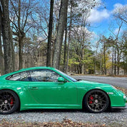 Oracal Gloss Police Green installed on a car parked on a road with trees