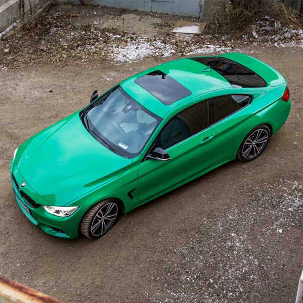 Oracal Gloss Police Green installed on a car parked on a concrete surface with snow patches