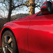 Oracal Gloss Luscious Lips installed on a car parked next to a tree