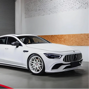 Matt white wrapped luxury car parked in a garage with a brick wall background