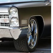 Close-up of a classic car's front wheel and headlight with Oracal super matt black vinyl wrap installed