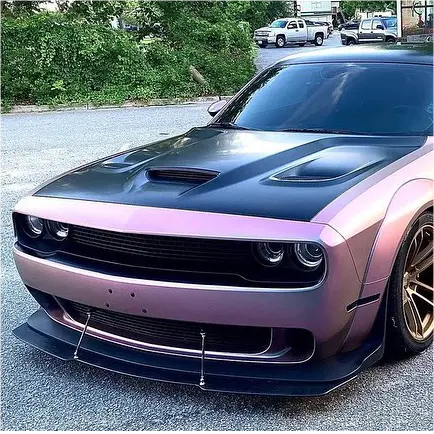 Matte pearl symphony wrapped car with a black bonnet on a street with greenery in the background