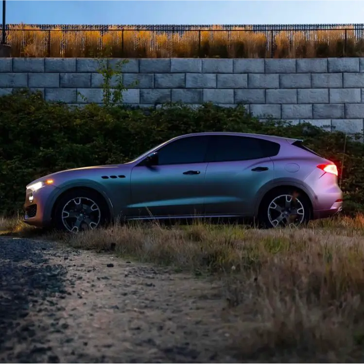 Luxury SUV parked on a dirt road with an Oracal matte pearl symphony car wrap installed