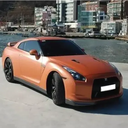 Sports car with Oracal matte red L metalliccar wrap installed with a rivrer in the background
