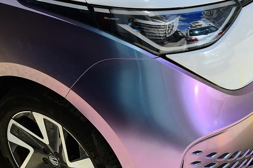 Close-up of a car's headlight and front grille with Oracal Gloss Amethyst installed