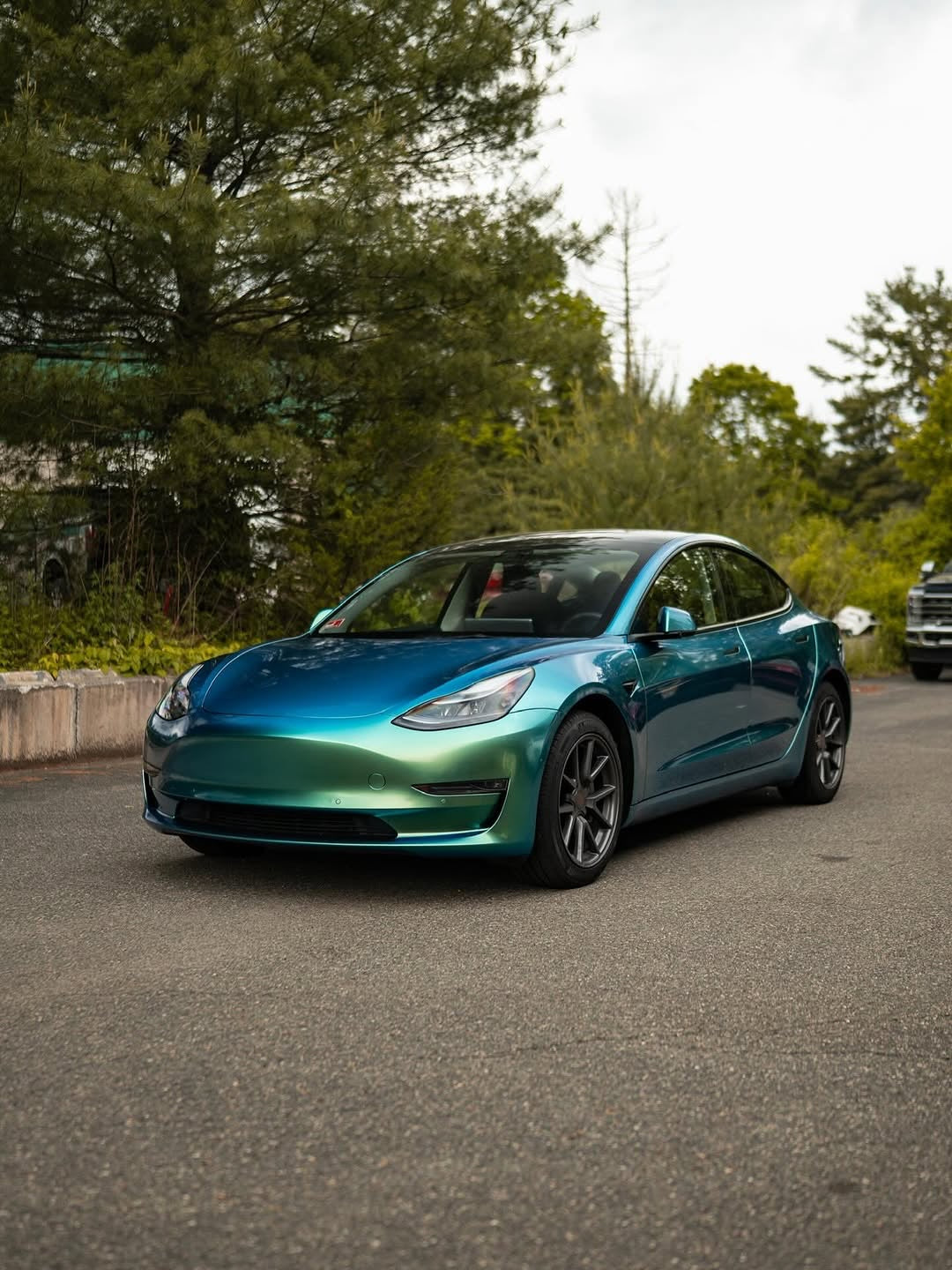 Oracal Gloss Aquamarine installed on a car parked on a road with trees