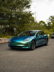Oracal Gloss Aquamarine installed on a car parked on a road with trees