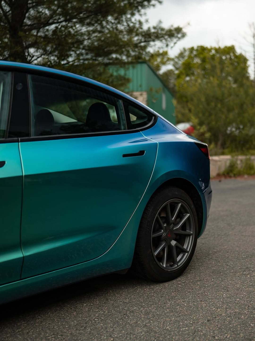 Oracal Gloss Aquamarine installed on a car parked on a road with trees