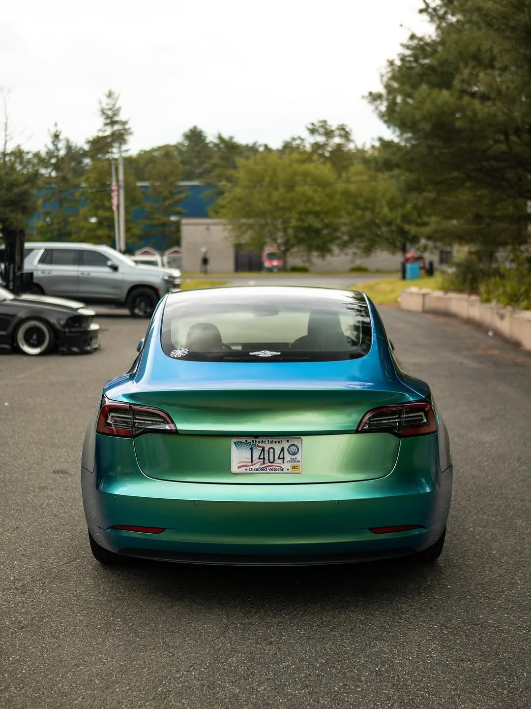 Oracal Gloss Aquamarine installed on a car on a road with trees and buildings