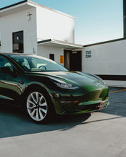 Oracal Gloss Bottle Green Tesla car parked in front of a building with 'Stair Down' sign