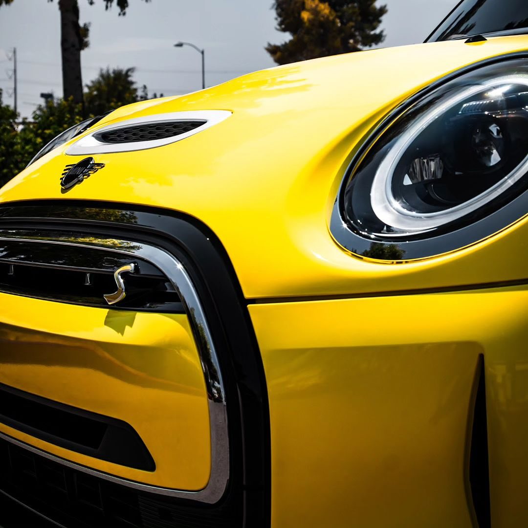 Close-up of an Oracal Gloss Canary Yellow wrap installed on a Mini Cooper car's headlight 