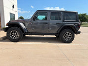 Oracal Gloss Charcoal Metallic installed on a Jeep Wrangler parked on a concrete surface with a building and trees