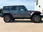 Oracal Gloss Charcoal Metallic installed on a Jeep Wrangler parked on a concrete surface with a building
