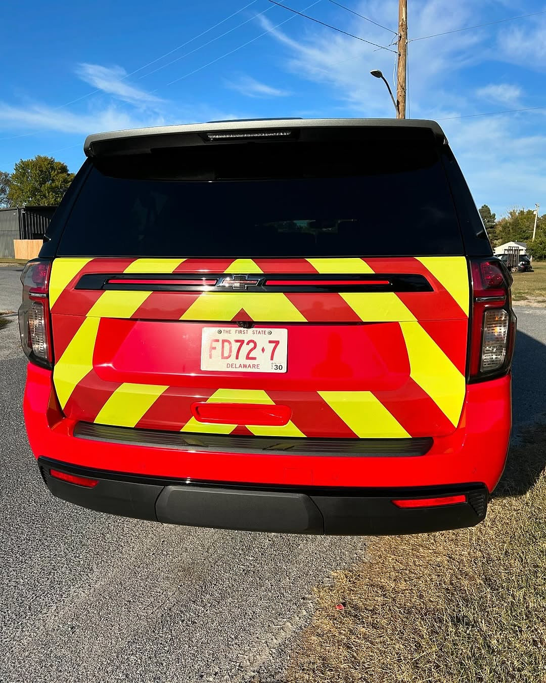 Oracal Gloss Chili Red installed on a vehicle with yellow and red reflective stripes on a road