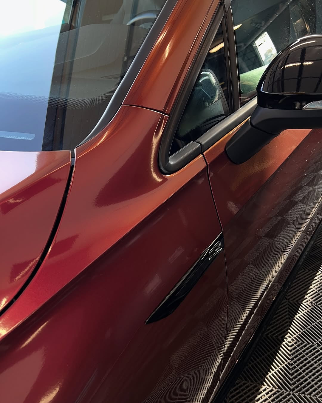 Close-up of an Oracal Gloss Cranberry car door with a side mirror reflection