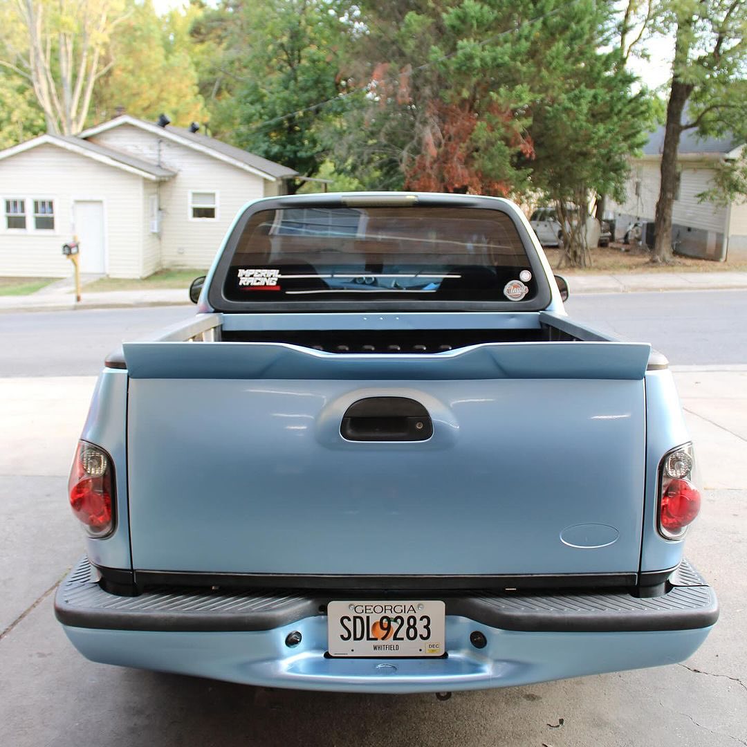 Oracal Gloss Dove Blue Metallic pickup truck parked on a residential street with trees and houses 
