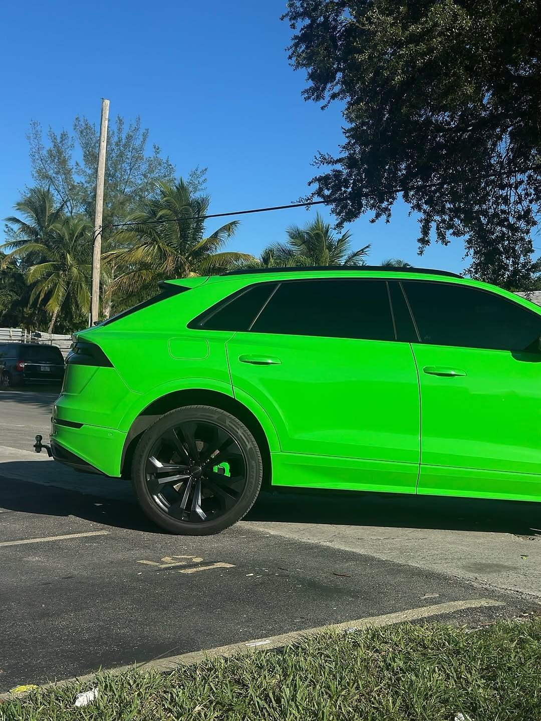 Oracal Gloss Grass Green SUV parked in a parking lot with trees and clear sky 