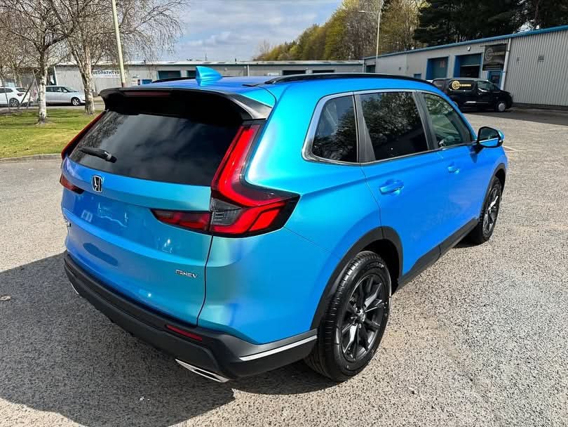 Rear view of Oracal Gloss Green Blue installed on an SUV parked on a paved surface with a building and trees