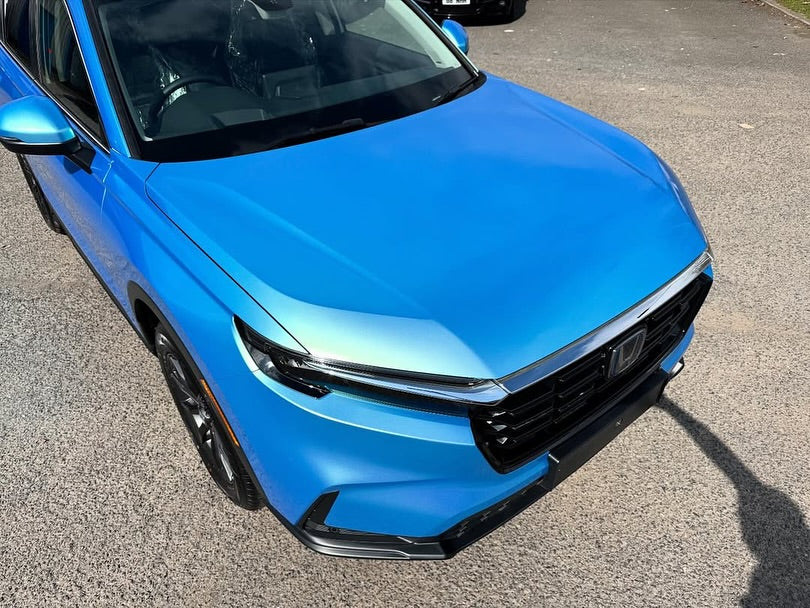 Front view of Oracal Gloss Green Blue installed on a car parked on a paved surface