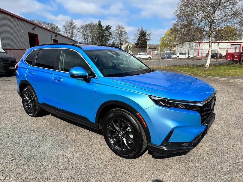 Oracal Gloss Green Blue installed on an SUV parked on a paved surface with a building and trees