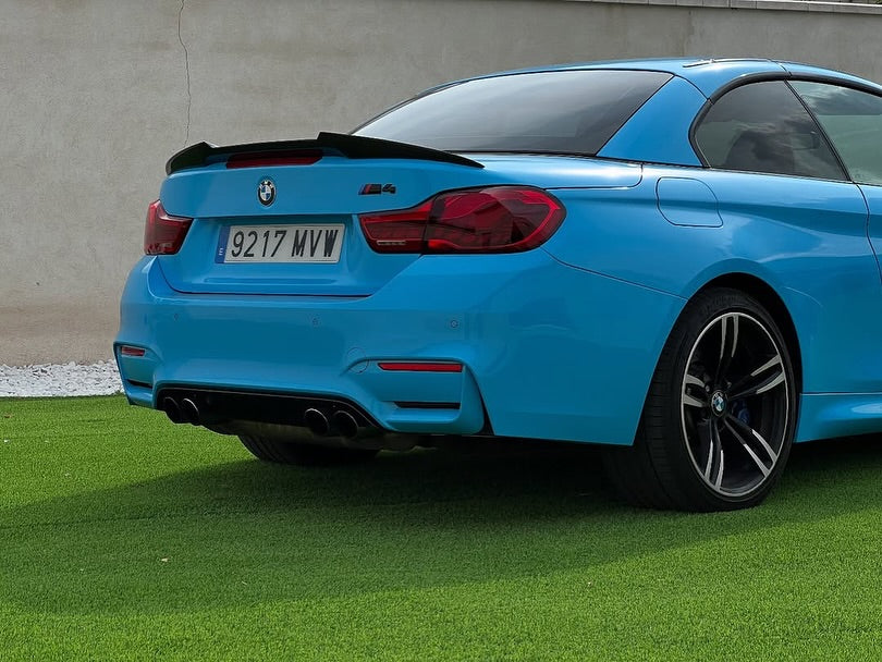 Oracal Gloss Ice Blue installed on a BMW car parked on grass with a beige wall