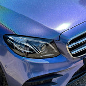 Close-up of a blue car's headlight and grille with Gloss Intergalactic Blue installed