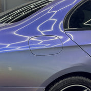 Close-up of a car's side panel with Oracal Gloss Intergalactic Blue installed