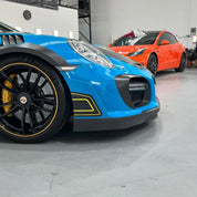 Oracal Gloss Lagoon sports car with black rims in a garage