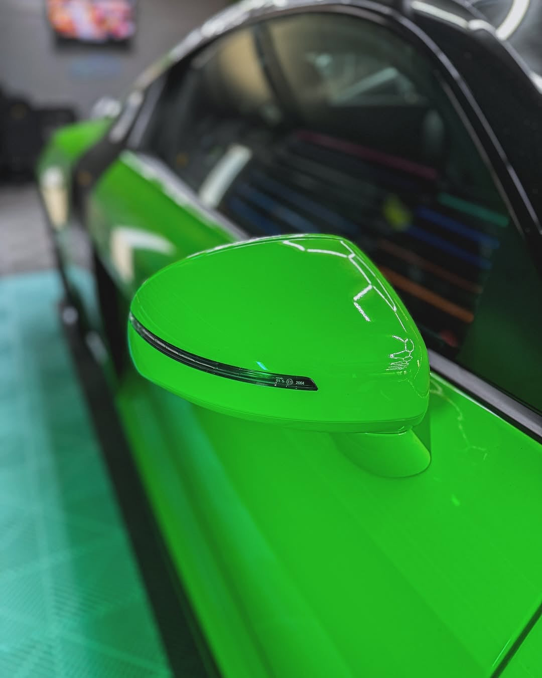 Close-up of an Oracal Gloss Lawn Green wrap on a car's side mirror