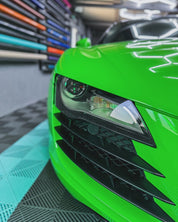 Close-up of an Oracal Gloss Lawn Green wrap on a car's front grille and headlight in a garage