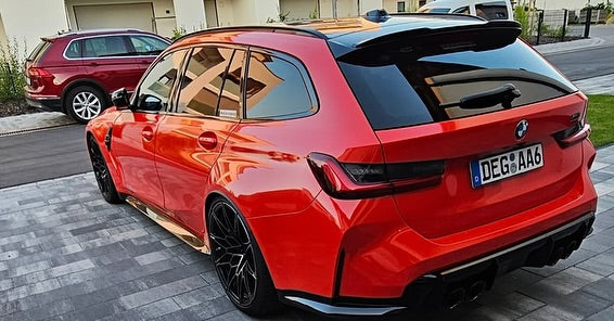 Rear view of Oracal Gloss Light Red installed on a BMW car parked on a driveway
