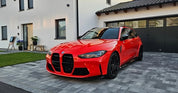 Oracal Gloss Light Red installed on a BMW car parked on a driveway in front of a house