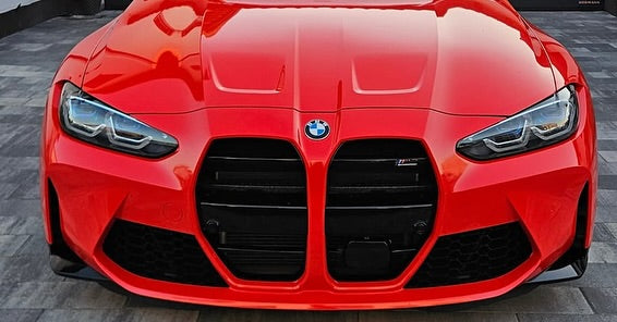 Oracal Gloss Light Red installed on a BMW car front view on a textured surface