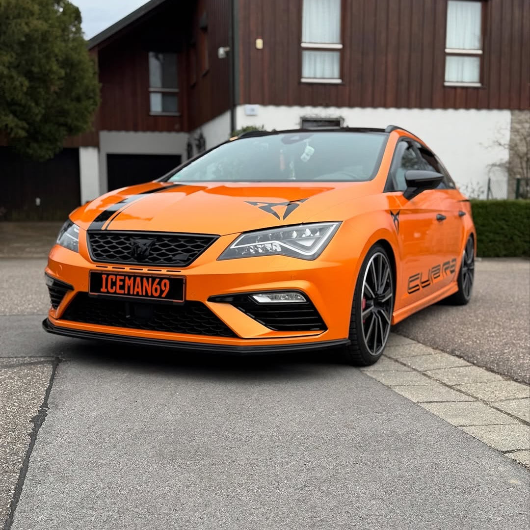 A car with Oracal Gloss Mandarin Metallic installed is parked on a street.