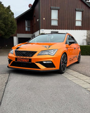 A car with Oracal Gloss Mandarin Metallic installed is parked on a street.