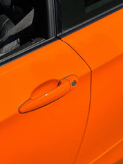 Close-up of an Oracal Gloss Municipal Orange on a car door with a handle