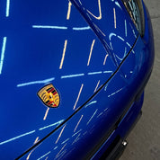 Oracal Gloss Night Blue Metallic ultra close-up car with Porsche logo