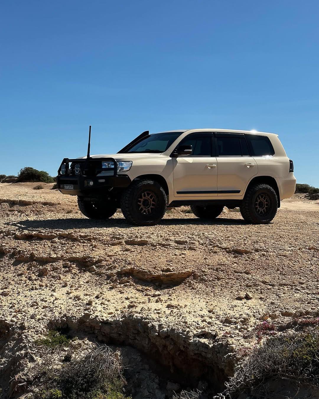 Oracal Gloss Papyrus SUV on a rocky desert landscape with clear blue sky