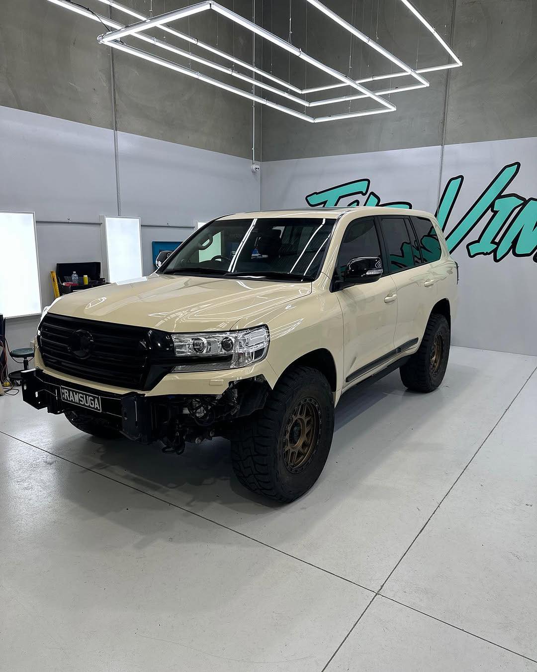 Oracal Gloss Papyrus SUV in a showroom with a brand logo on the wall