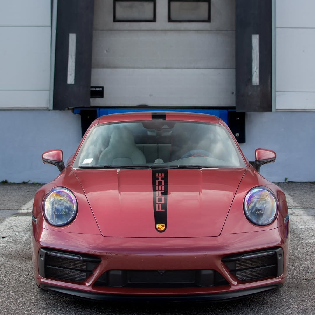 Oracal Gloss Red Brown Metallic installed on a Porsche car parked in front of a garage door
